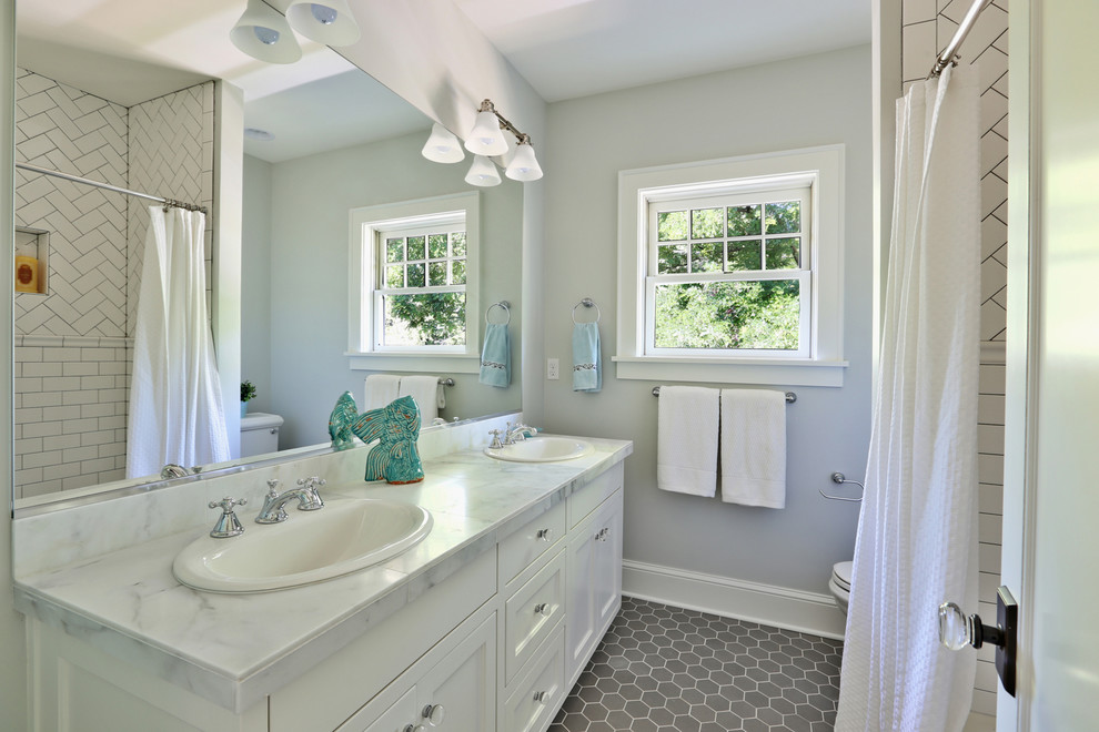Mid-sized transitional white tile and ceramic tile ceramic tile tub/shower combo photo in Portland with a drop-in sink, shaker cabinets, white cabinets, marble countertops and blue walls
