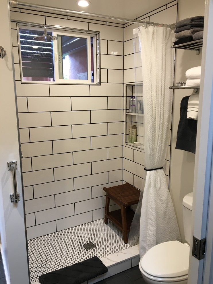 Cette image montre une petite salle de bain rustique avec un placard à porte plane, des portes de placard noires, WC séparés, un mur blanc, un lavabo intégré, un plan de toilette en quartz modifié, une cabine de douche avec un rideau et un plan de toilette blanc.
