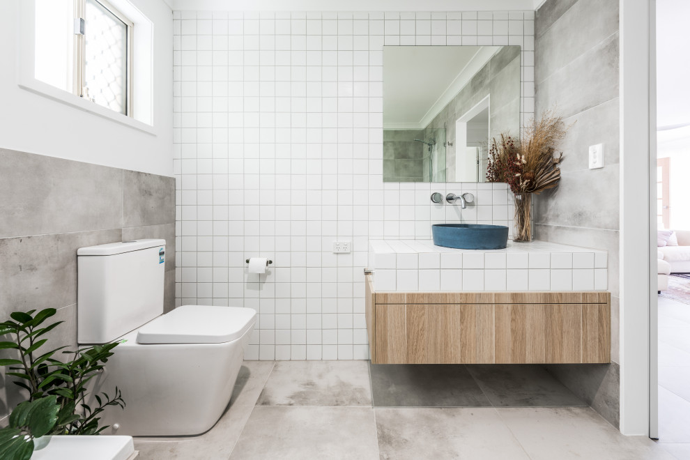 Пример оригинального дизайна: ванная комната в современном стиле с светлыми деревянными фасадами, белой плиткой, керамической плиткой, столешницей из плитки, белой столешницей, тумбой под одну раковину и подвесной тумбой