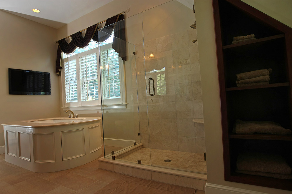 Cette photo montre une grande salle de bain principale chic en bois foncé avec un lavabo encastré, un placard à porte affleurante, un plan de toilette en marbre, un bain bouillonnant, une douche double, WC à poser, un carrelage beige, un carrelage de pierre, un mur beige et un sol en carrelage de porcelaine.