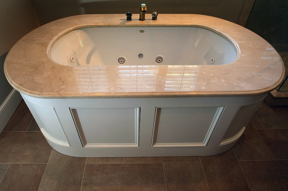 Large classic ensuite bathroom in Boston with beaded cabinets, dark wood cabinets, marble worktops, beige tiles, stone tiles, a submerged sink, a hot tub, a double shower, a one-piece toilet, beige walls and porcelain flooring.