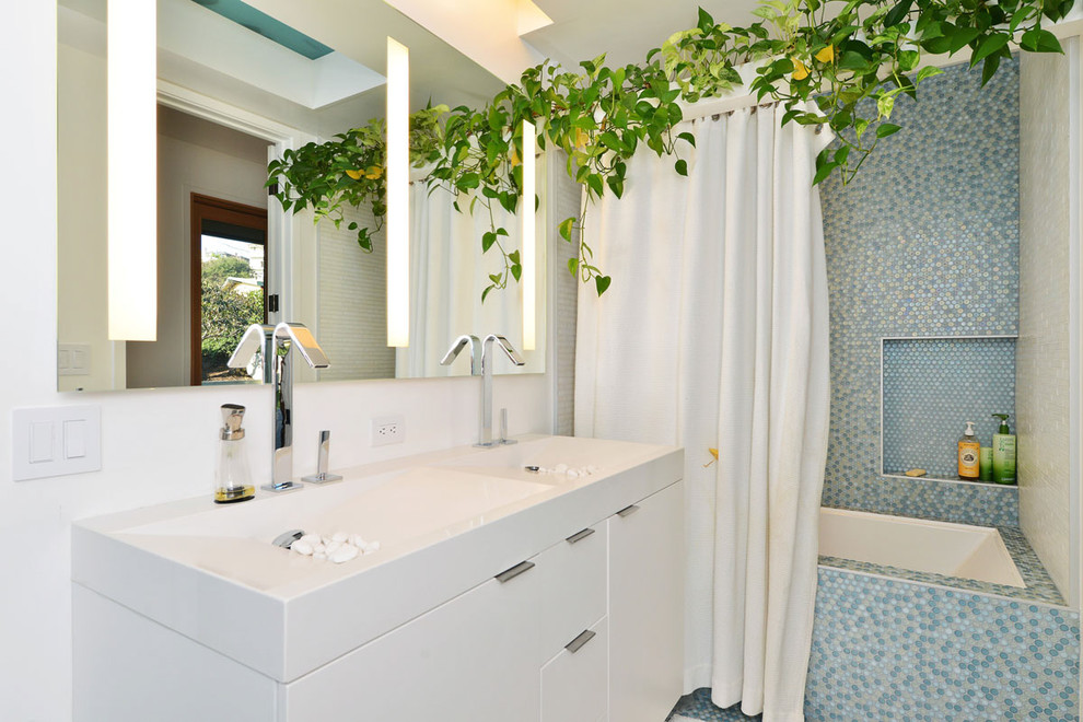 Foto di una stanza da bagno con doccia design di medie dimensioni con ante lisce, ante bianche, vasca ad alcova, vasca/doccia, piastrelle di vetro, pareti bianche, lavabo integrato e top in quarzite