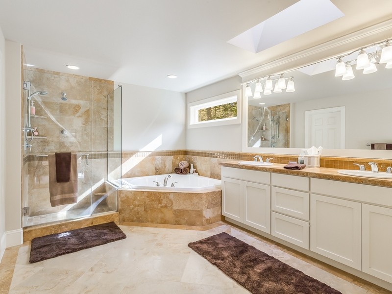 Inspiration för stora klassiska en-suite badrum, med ett nedsänkt handfat, luckor med infälld panel, vita skåp, bänkskiva i kalksten, ett platsbyggt badkar, en dusch i en alkov, stenkakel, vita väggar, klinkergolv i keramik och brun kakel