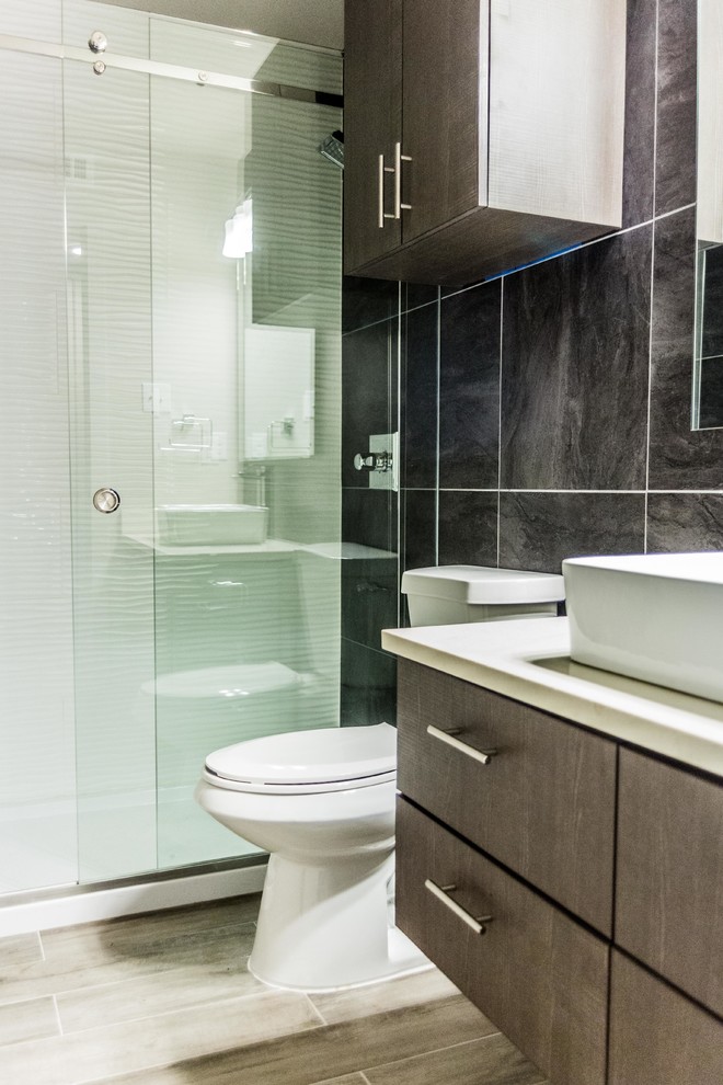 Medium sized contemporary shower room bathroom in Dallas with flat-panel cabinets, dark wood cabinets, an alcove shower, a one-piece toilet, a vessel sink, a sliding door and engineered stone worktops.