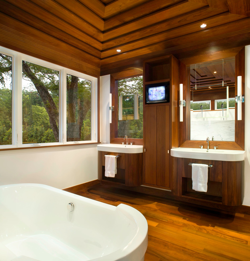 Свежая идея для дизайна: ванная комната в стиле неоклассика (современная классика) с плоскими фасадами, темными деревянными фасадами, отдельно стоящей ванной и окном - отличное фото интерьера