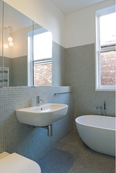 Aménagement d'une salle de bain contemporaine avec un lavabo suspendu, une baignoire indépendante, WC suspendus, un carrelage gris, mosaïque, un mur blanc et un sol en carrelage de terre cuite.
