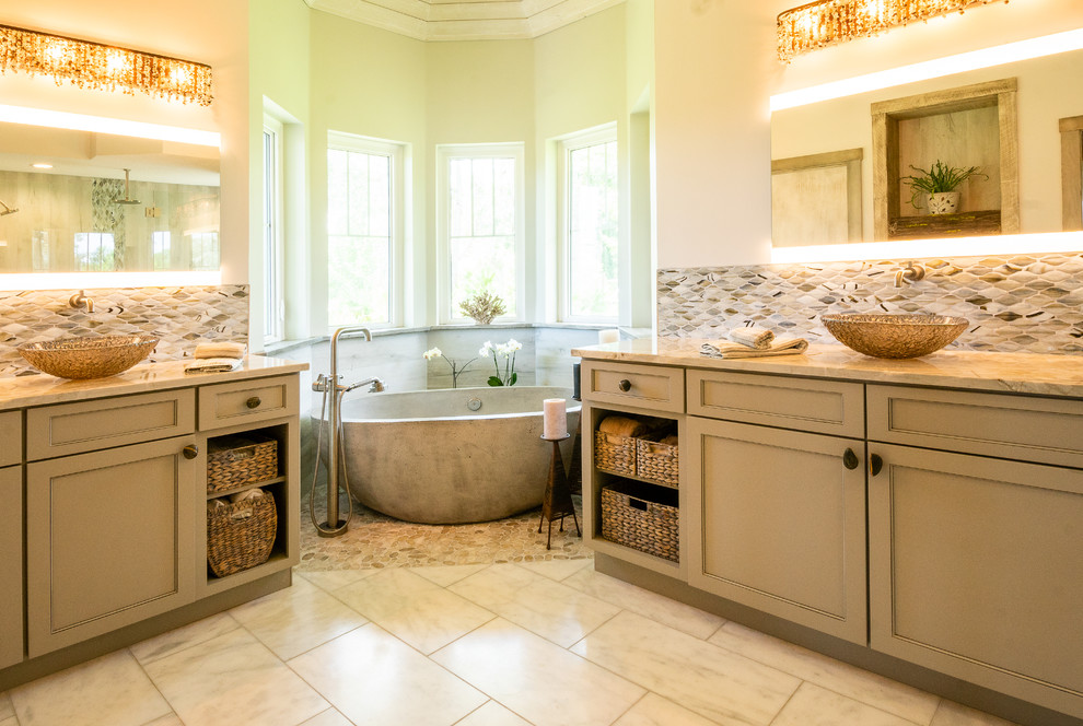 Freestanding bathtub - coastal master beige floor freestanding bathtub idea in Jacksonville with recessed-panel cabinets, beige cabinets, beige walls, a vessel sink and beige countertops