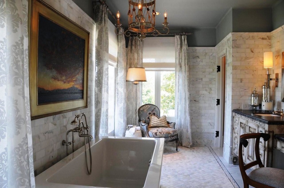 Foto de cuarto de baño tradicional con lavabo bajoencimera, puertas de armario con efecto envejecido, baldosas y/o azulejos grises y armarios con paneles con relieve