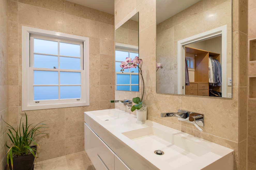 Пример оригинального дизайна: ванная комната в современном стиле с бежевой плиткой, бежевыми стенами и монолитной раковиной