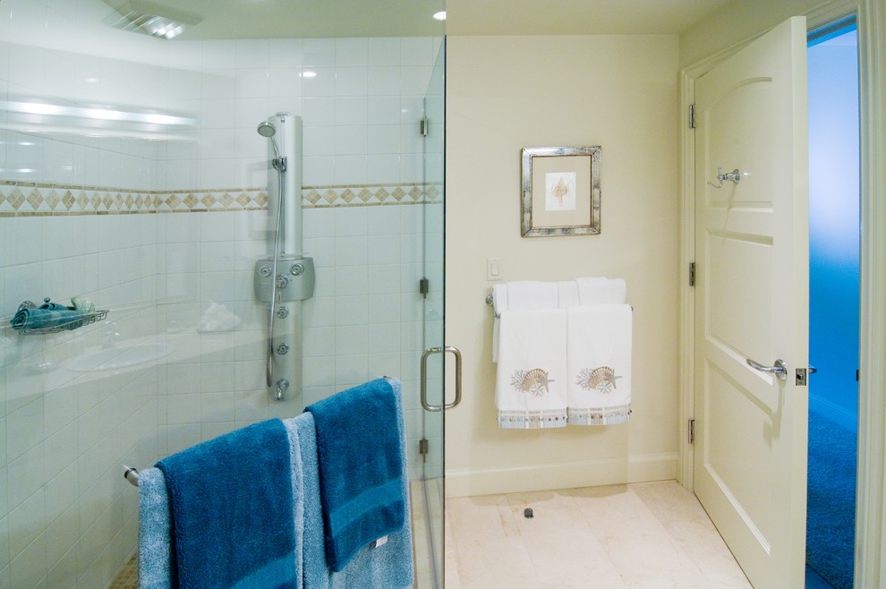 Идея дизайна: ванная комната в морском стиле с плоскими фасадами, белыми фасадами, угловым душем, унитазом-моноблоком, бежевой плиткой, каменной плиткой, бежевыми стенами, полом из известняка, накладной раковиной и столешницей из известняка