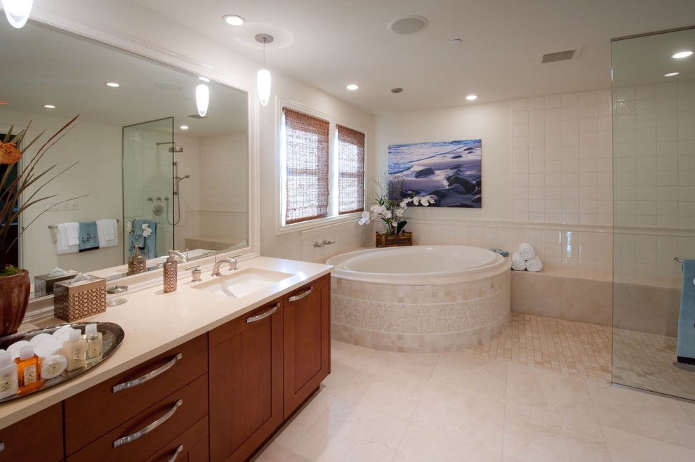 Exemple d'une salle de bain principale exotique en bois brun avec un placard à porte shaker, une baignoire posée, une douche à l'italienne, WC à poser, un carrelage beige, un carrelage de pierre, un mur beige, un sol en calcaire, un lavabo encastré et un plan de toilette en calcaire.