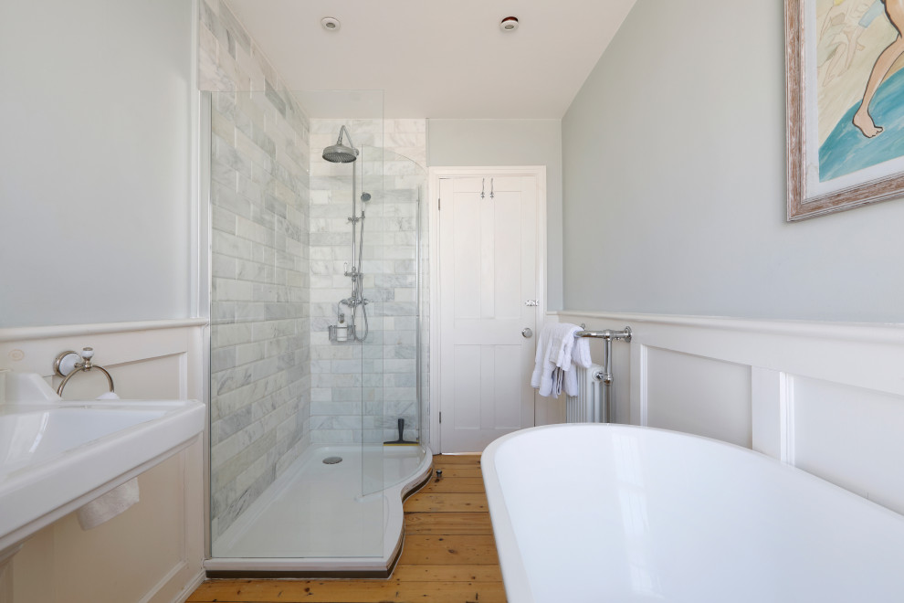 This is an example of a mid-sized traditional kids bathroom in Sussex with a claw-foot tub, an open shower, a two-piece toilet, grey walls, medium hardwood floors, a console sink, brown floor, an open shower and a single vanity.