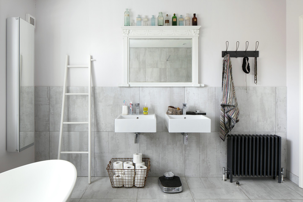 Large scandinavian family bathroom in Sussex with flat-panel cabinets, white cabinets, a freestanding bath, a walk-in shower, a wall mounted toilet, grey tiles, ceramic tiles, grey walls, ceramic flooring and a wall-mounted sink.