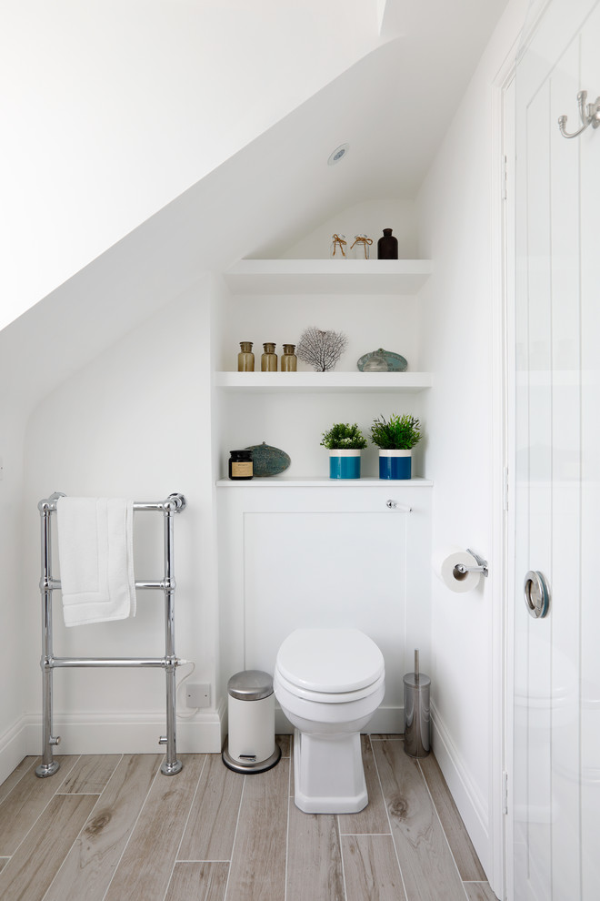 Inredning av ett modernt litet en-suite badrum, med luckor med infälld panel, vita skåp, en kantlös dusch, vita väggar, klinkergolv i keramik, ett nedsänkt handfat, laminatbänkskiva, beiget golv, dusch med skjutdörr och en toalettstol med separat cisternkåpa