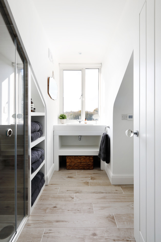 Inspiration för små moderna en-suite badrum, med vita skåp, vita väggar, klinkergolv i keramik, laminatbänkskiva, beiget golv, dusch med skjutdörr, öppna hyllor, en toalettstol med separat cisternkåpa och ett konsol handfat
