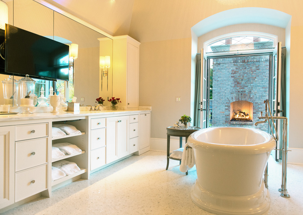 Immagine di una grande stanza da bagno con ante lisce, ante bianche, vasca freestanding, pareti beige, pavimento con piastrelle a mosaico e top in marmo