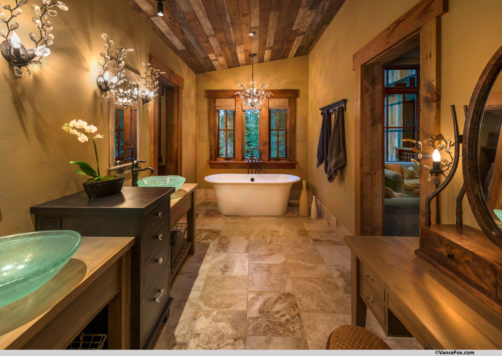 Cette image montre une grande salle de bain principale chalet avec un placard en trompe-l'oeil, une baignoire indépendante, un mur marron, un sol en carrelage de céramique, une vasque, un plan de toilette en bois et un sol marron.