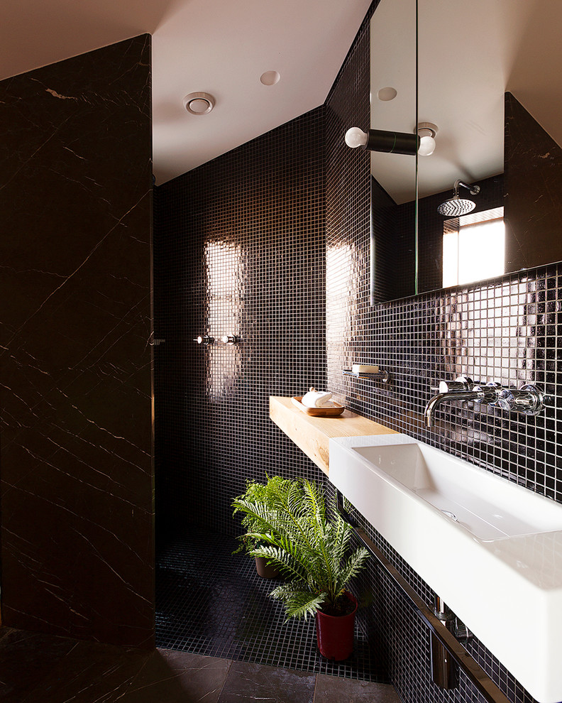 Immagine di una stanza da bagno con doccia minimal con doccia a filo pavimento, piastrelle nere, pareti nere, lavabo rettangolare e doccia aperta