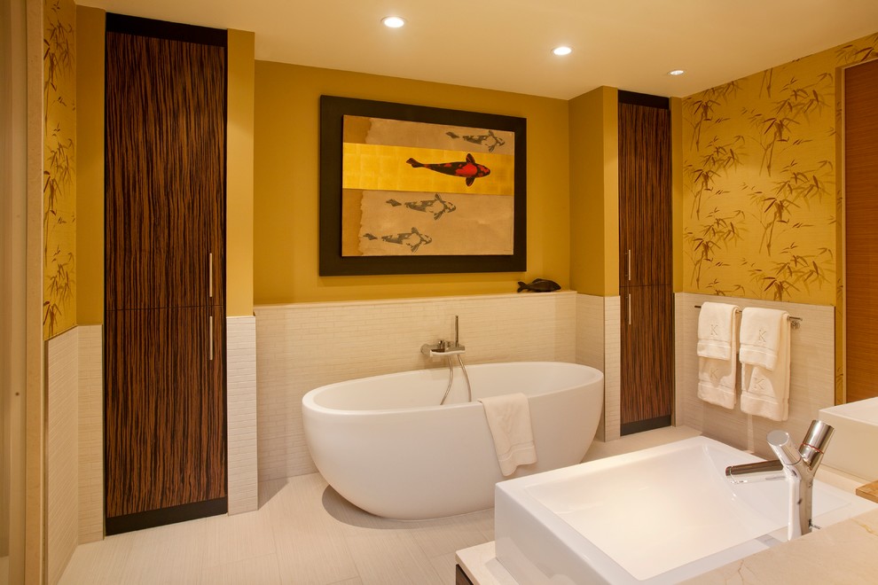 На фото: большая главная ванная комната в восточном стиле с отдельно стоящей ванной, белой плиткой, желтыми стенами, полом из керамогранита, настольной раковиной и белым полом с