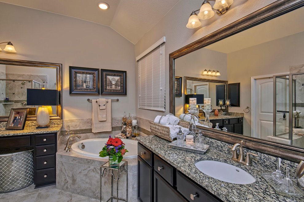 Inredning av ett klassiskt stort en-suite badrum, med skåp i shakerstil, bruna skåp, ett fristående badkar, en hörndusch, beige kakel, svart och vit kakel, beige väggar, marmorgolv, ett undermonterad handfat och granitbänkskiva