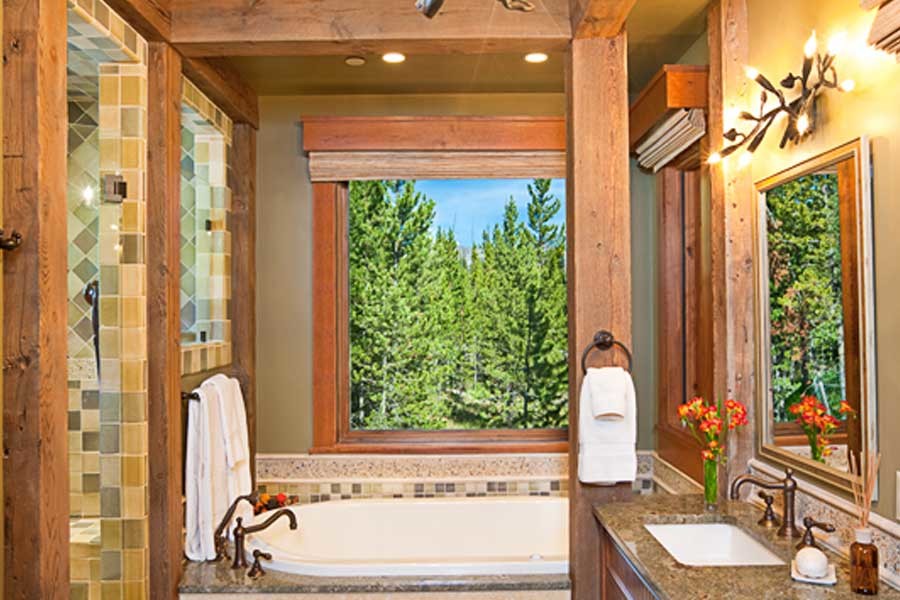 Réalisation d'une salle de bain principale chalet en bois brun avec un placard avec porte à panneau encastré, une baignoire posée, mosaïque, un mur marron, un sol en carrelage de céramique, un lavabo encastré et un plan de toilette en granite.