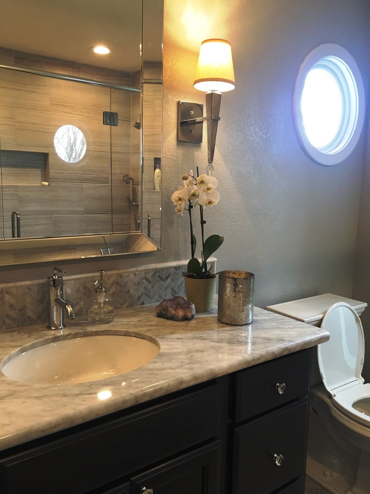 This is an example of a medium sized classic ensuite bathroom in Sacramento with recessed-panel cabinets, black cabinets, an alcove shower, grey tiles, stone tiles, grey walls, dark hardwood flooring, a submerged sink, quartz worktops, grey floors, a hinged door and grey worktops.