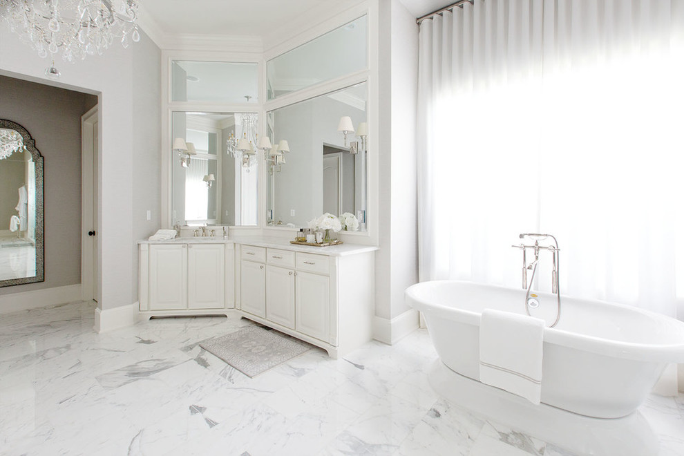 Inspiration for a classic ensuite bathroom in Orange County with raised-panel cabinets, white cabinets, a freestanding bath, an alcove shower, grey tiles, white tiles, stone tiles, grey walls, marble flooring and marble worktops.