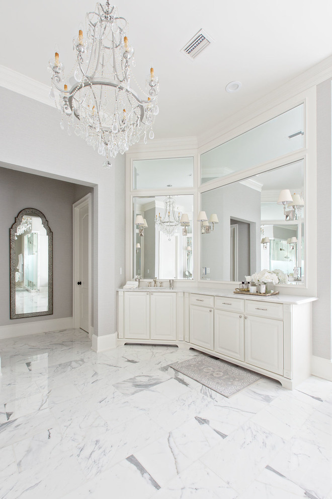 Inredning av ett klassiskt en-suite badrum, med luckor med upphöjd panel, vita skåp, ett fristående badkar, en dusch i en alkov, grå kakel, vit kakel, stenkakel, grå väggar, marmorgolv och marmorbänkskiva