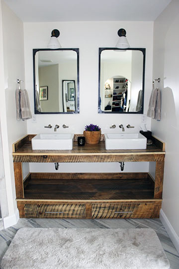 Cette photo montre une salle de bain principale éclectique en bois vieilli de taille moyenne avec un plan de toilette en bois, une baignoire indépendante, un carrelage gris, un carrelage de pierre, un mur blanc et un sol en marbre.