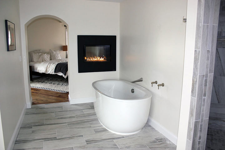 Aménagement d'une salle de bain principale éclectique de taille moyenne avec une baignoire indépendante, un carrelage gris, un carrelage de pierre, un mur blanc et un sol en marbre.