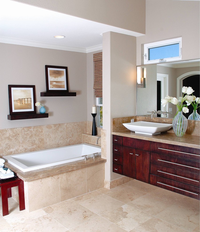 На фото: ванная комната в современном стиле с настольной раковиной и плиткой из травертина с