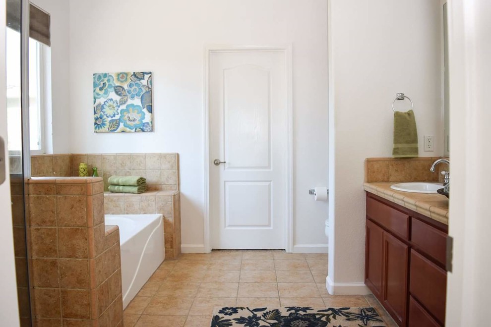Пример оригинального дизайна: главная ванная комната среднего размера в классическом стиле с фасадами в стиле шейкер, темными деревянными фасадами, бежевой плиткой, столешницей из плитки, ванной в нише, угловым душем, унитазом-моноблоком, белыми стенами, накладной раковиной, бежевым полом и душем с распашными дверями