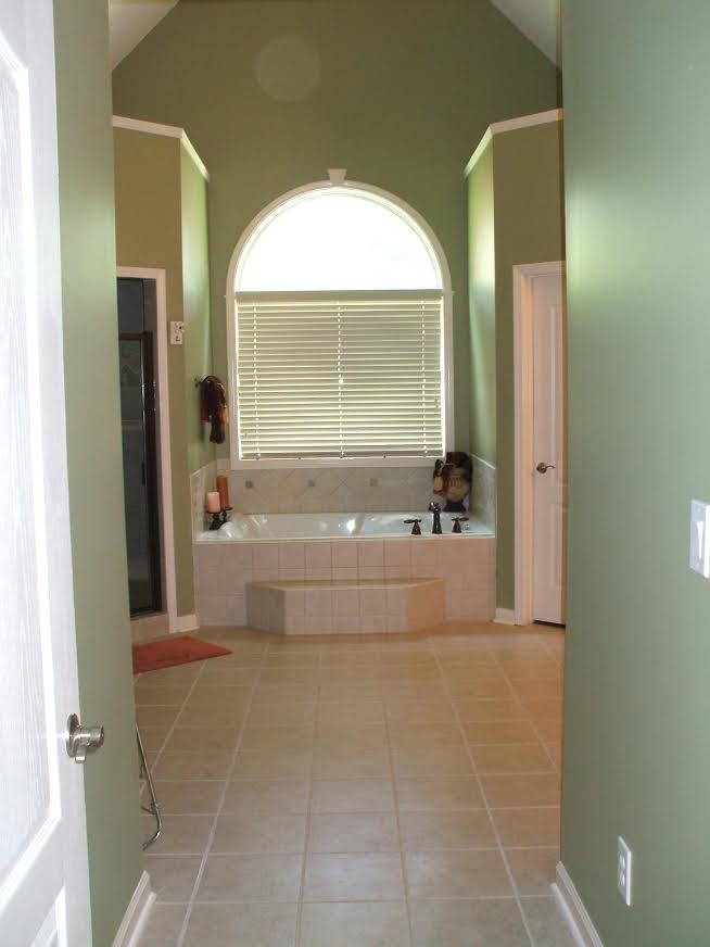 Exemple d'une grande salle de bain principale chic avec une baignoire en alcôve, un carrelage beige, des carreaux de porcelaine, un mur vert et un sol en carrelage de porcelaine.