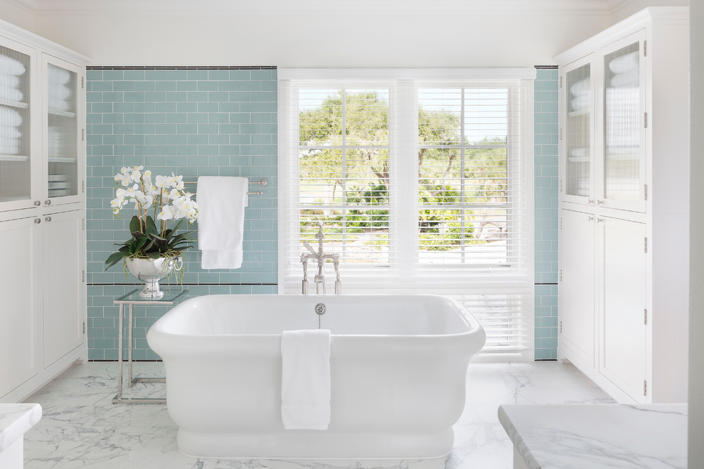 Ejemplo de cuarto de baño rectangular clásico con armarios estilo shaker, puertas de armario blancas, bañera exenta, baldosas y/o azulejos azules, baldosas y/o azulejos de vidrio y paredes blancas