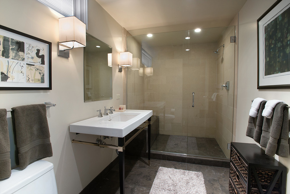 Small minimalist 3/4 beige tile and ceramic tile slate floor and gray floor alcove shower photo in Orange County with beige walls, furniture-like cabinets, black cabinets, a two-piece toilet, an integrated sink, solid surface countertops and a hinged shower door