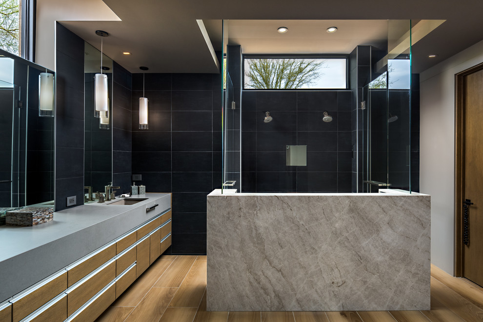 Design ideas for a contemporary ensuite bathroom in Phoenix with flat-panel cabinets, medium wood cabinets, a double shower, black tiles, light hardwood flooring, a submerged sink, beige floors, grey worktops, white walls and a hinged door.