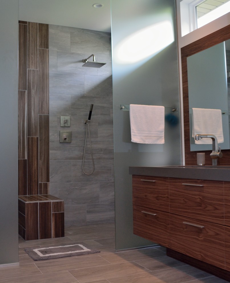Mid-sized island style master gray tile and ceramic tile ceramic tile double shower photo in Milwaukee with a trough sink, flat-panel cabinets, medium tone wood cabinets, solid surface countertops, a two-piece toilet and white walls