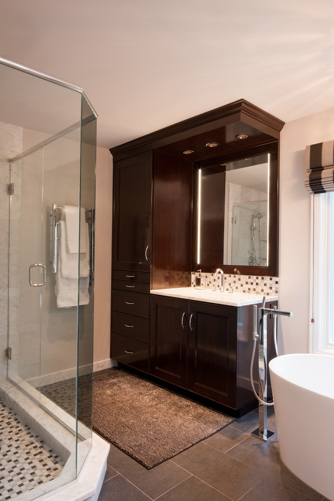 Bathroom - large transitional master white tile and glass tile porcelain tile and brown floor bathroom idea in Houston with raised-panel cabinets, dark wood cabinets, white walls, an undermount sink, marble countertops and a hinged shower door