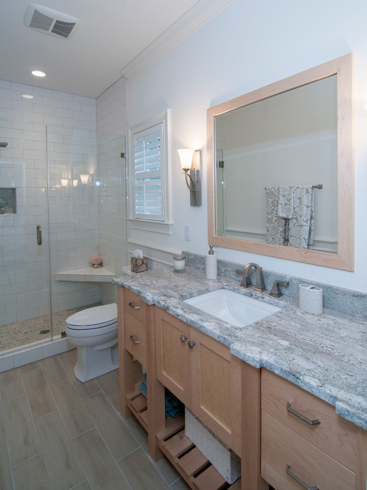 Idee per una stanza da bagno costiera con lavabo sottopiano, ante in stile shaker, ante in legno chiaro, top in granito, pareti grigie e pavimento in gres porcellanato
