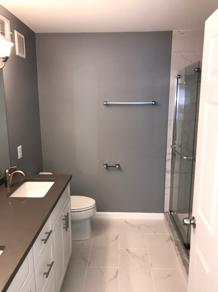 Aménagement d'une douche en alcôve principale contemporaine de taille moyenne avec un placard à porte shaker, des portes de placard blanches, WC séparés, un carrelage blanc, des carreaux de porcelaine, un mur gris, un sol en carrelage de porcelaine, un lavabo encastré, un plan de toilette en quartz, un sol blanc, une cabine de douche à porte coulissante, un plan de toilette gris, une niche, meuble double vasque et meuble-lavabo encastré.