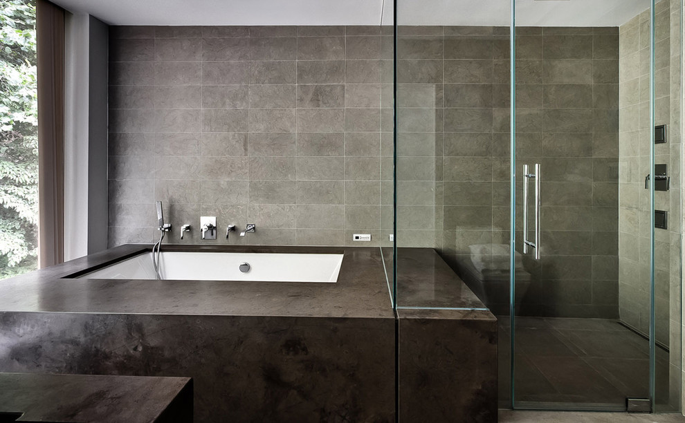 Diseño de cuarto de baño minimalista con bañera encastrada sin remate, ducha esquinera y baldosas y/o azulejos grises
