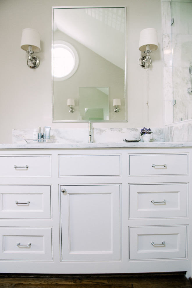 Inredning av ett klassiskt mellanstort en-suite badrum, med släta luckor, vita skåp, ett fristående badkar, en dubbeldusch, vit kakel, stenkakel och marmorbänkskiva