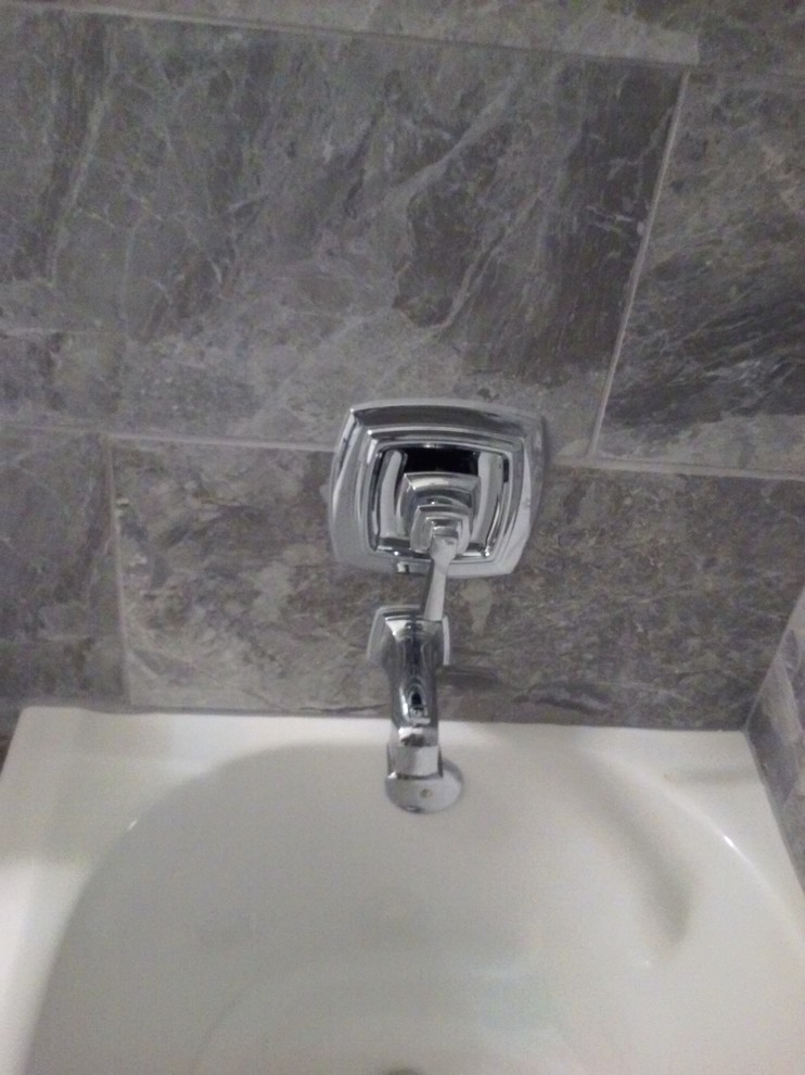 Modern inredning av ett mellanstort badrum med dusch, med ett undermonterad handfat, möbel-liknande, vita skåp, marmorbänkskiva, en dusch/badkar-kombination, en toalettstol med hel cisternkåpa, grå kakel, porslinskakel, gröna väggar och klinkergolv i porslin