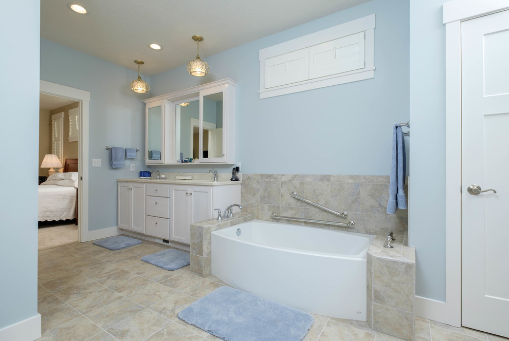 Small traditional ensuite bathroom in Other with recessed-panel cabinets, white cabinets, an alcove bath, a shower/bath combination, a two-piece toilet, white tiles, stone tiles, blue walls, travertine flooring, a submerged sink and granite worktops.