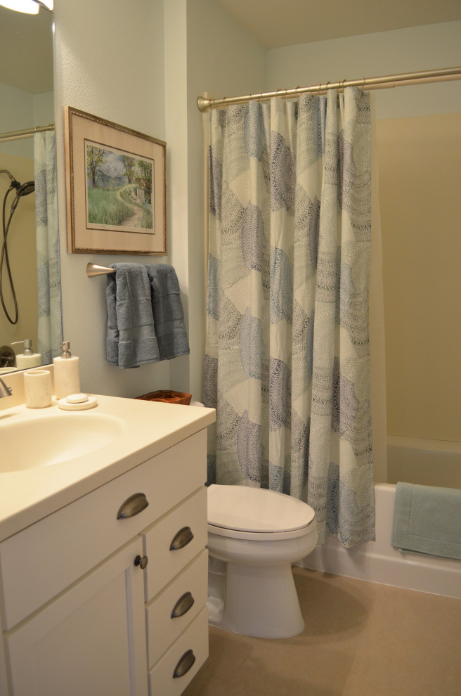 Exempel på ett mellanstort modernt beige beige badrum, med skåp i shakerstil, vita skåp, ett platsbyggt badkar, våtrum, en toalettstol med separat cisternkåpa, blå väggar, linoleumgolv, ett integrerad handfat, bänkskiva i akrylsten, beiget golv och dusch med duschdraperi