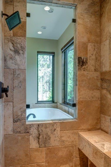 This is an example of a rustic bathroom in Portland with brown tiles and travertine tiles.