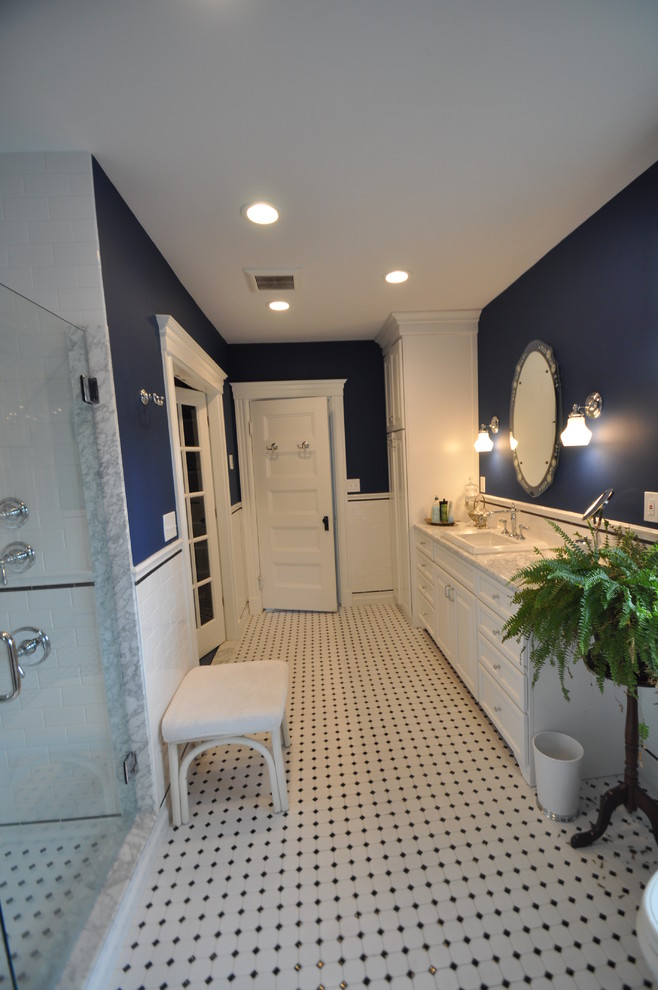 Идея дизайна: большая главная ванная комната в стиле неоклассика (современная классика) с фасадами с выступающей филенкой, белыми фасадами, угловым душем, белой плиткой, керамической плиткой, синими стенами, полом из керамической плитки, накладной раковиной, столешницей из гранита, белым полом и душем с распашными дверями