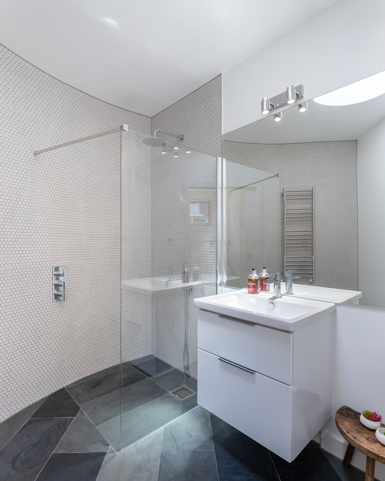 Стильный дизайн: ванная комната среднего размера в современном стиле с плоскими фасадами, белыми фасадами, душем без бортиков, белой плиткой, белыми стенами, полом из сланца, серым полом, открытым душем, белой столешницей и монолитной раковиной - последний тренд
