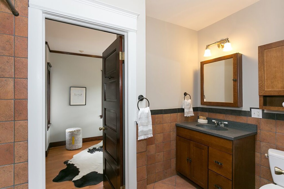 Esempio di una stanza da bagno con doccia american style di medie dimensioni con ante lisce, ante in legno scuro, piastrelle marroni, piastrelle in terracotta, pareti bianche, pavimento in terracotta, lavabo integrato, pavimento marrone e top grigio