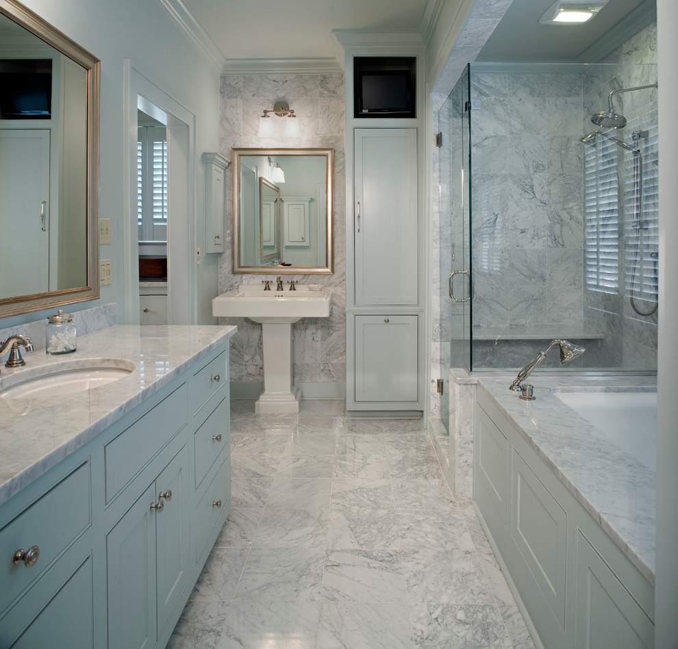 ニューオリンズにある高級なトラディショナルスタイルのおしゃれな浴室 (ペデスタルシンク、青いキャビネット、アンダーマウント型浴槽、コーナー設置型シャワー、白いタイル、落し込みパネル扉のキャビネット) の写真